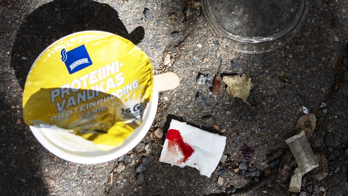 Kivetyksellä lojuu tyhjäksi syöty proteiinivanukaspurkki, verinen sidetaitos, käytetty neula ja nuuskaa.