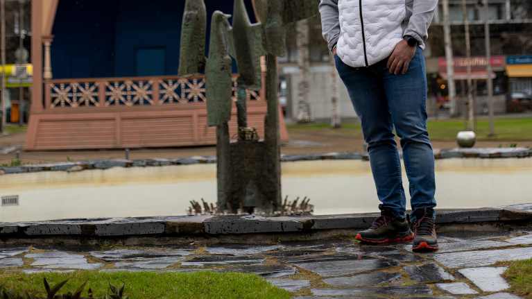 Kalju, parrakas, farkkuihin ja valkoharmaaseen pusakkaan pukeutunut keski-ikäinen mies seisoo lintuja esittävän patsaan vieressä Mikkelin keskustassa.