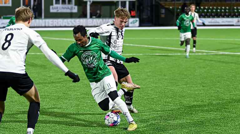 En EIF-spelare försöker finta två TPS-spelare.