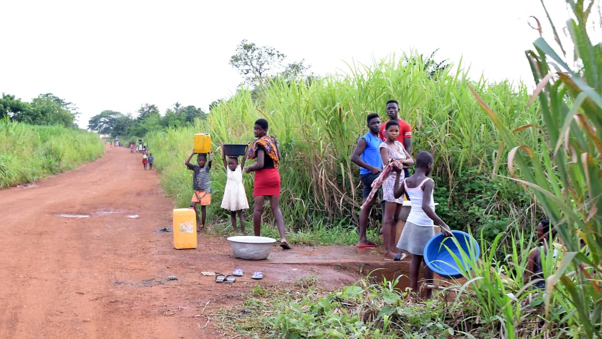 Afrikkalaisia naisia ja lapsia hakemassa vettä joesta