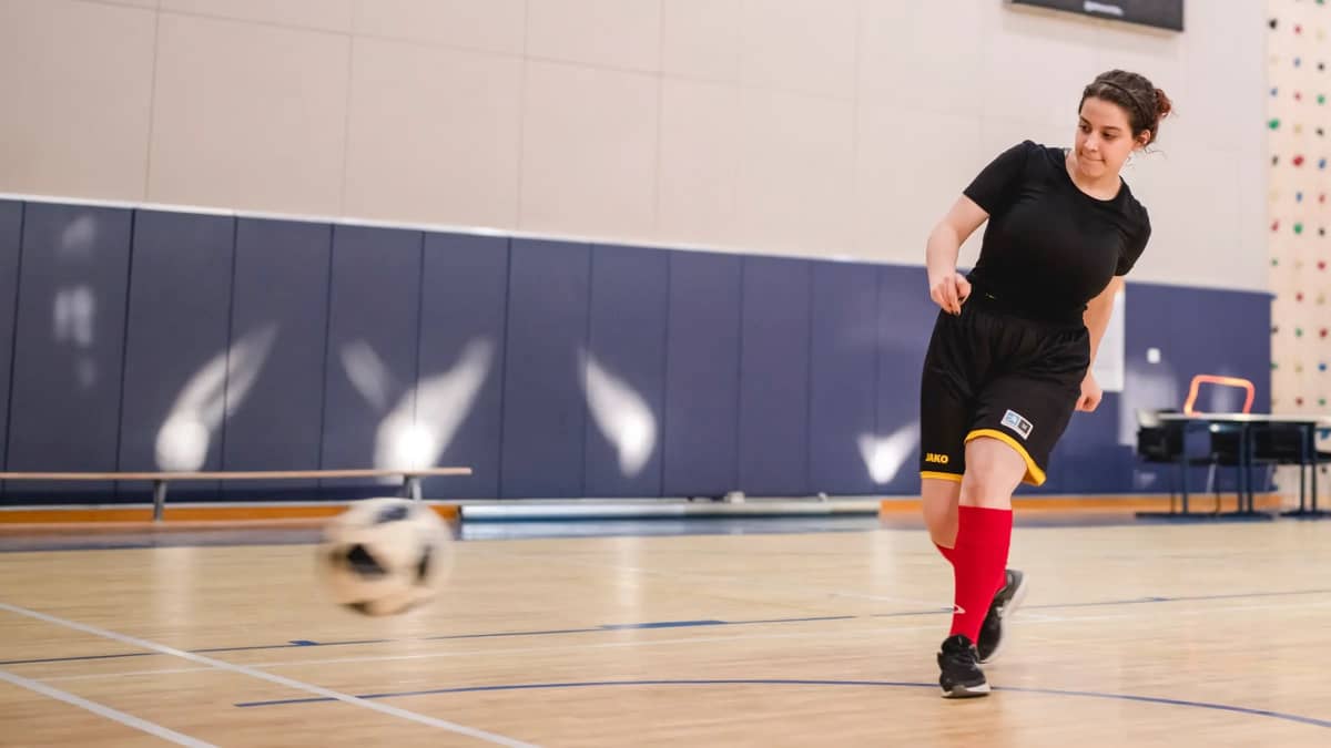 Qatarilainen naisjalkapalloilija Ghaida potkaisee palloa.