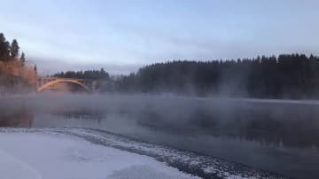 Aamun taikaa Kymijoen rannalla. Joki savuaa, silta yli joen. 