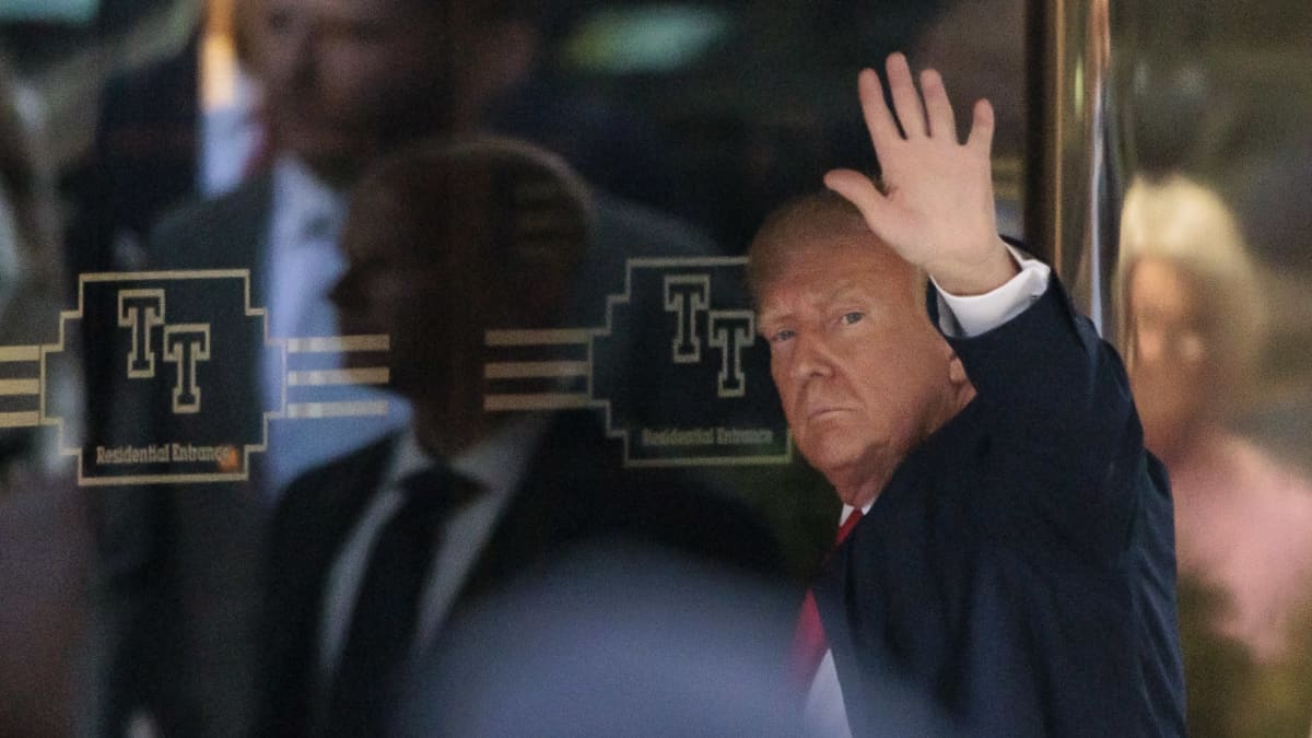 Trump heiluttaa kättään New Yorkin Trump Towerin ovella.