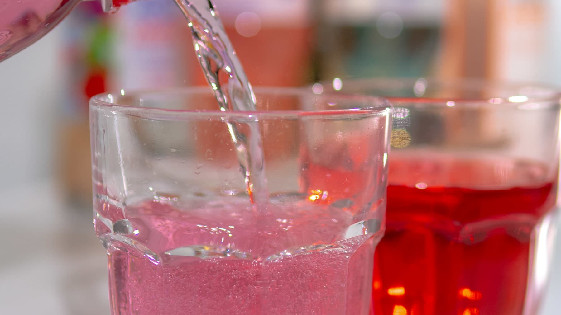 Pinkkiä vitamiinijuomaa kaadetaan lasiin.