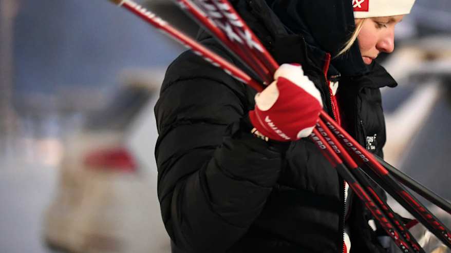 Image 1: Anni Lindroos looking to the right and leaning on her poles.