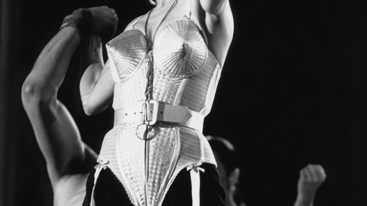 Mustavalkokuvassa poptähti Madonna laulaa päällään alusbody, jossa on terävät rintakupit.