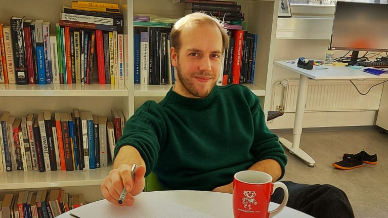 Yhteiskuntatieteiden tohtori Georg Boldt istuu työpöytänsä ääressä Helsingin yliopistossa.
