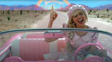 Barbie laulaa vaaleanpunaisessa autossa.