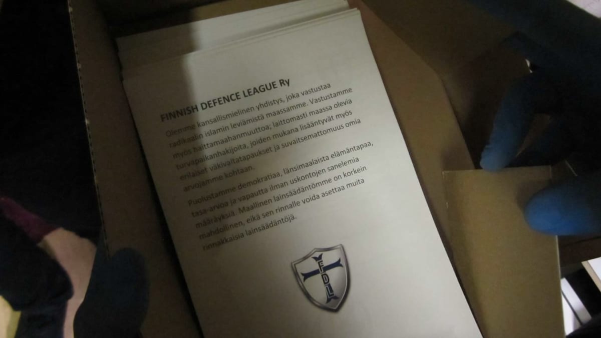 Paperipino pahvilaatikossa. Papereissa on Finnish Defence League -nimisen äärioikeistojärjestön propagandaa. 
