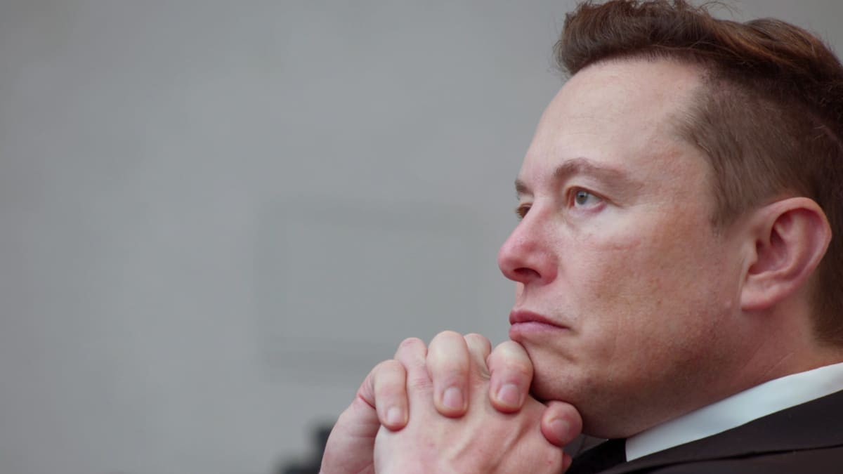 Elon Musk nojaa leukaansa käsiinsä.