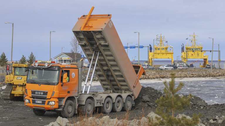Kuorma-auto kippaa kiviainesta Hailuodon siltatyömaan avajaispäivänä 6.5.2024.