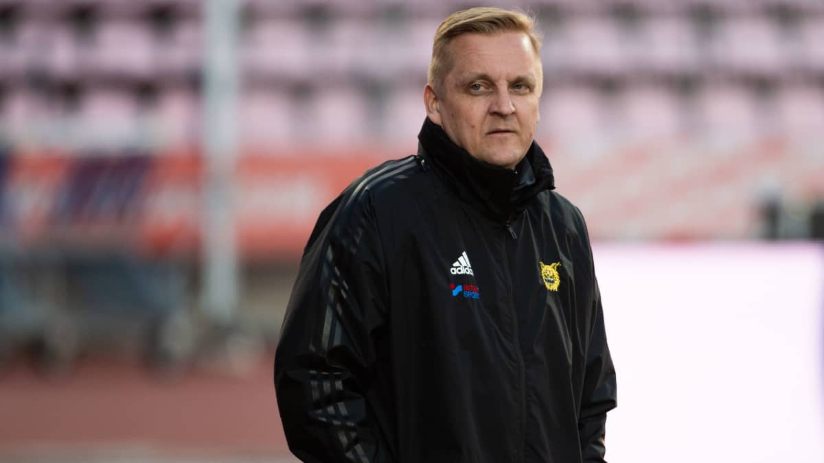 Valmentaja Jarkko Wiss seisoo kentän laidalla mustassa takissa. Wiss valmensi Tampereen Ilvestä. 