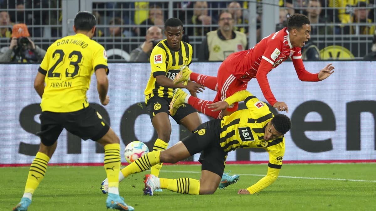 Dortmundin Jude Bellingham taklaa Bayernin Jamal Musialaa Bundesliigan ottelussa 8.10.2022.
