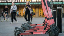 Sähköpotkulautoja rivissä helsingin rautatieaseman edessä.