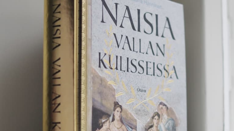 Kirjan kannessa on roomalaisia naisia piirroksessa. Heillä on yllään vaaleanväriset toogat.