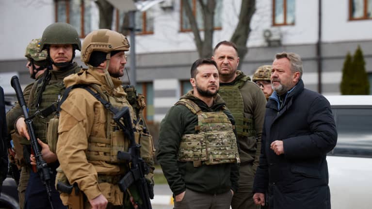 Presidentti Zelenskyi ja Buchan pormestari Anatoliy Fedoruk sotilaiden ympäröimänä. Zelenzkyillä on luotiliivit ja vakava ilme. 
