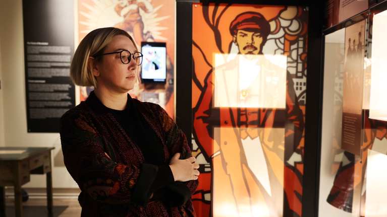 Tutkija Katarina Lenin-museossa taustallaan kuva Leninistä.