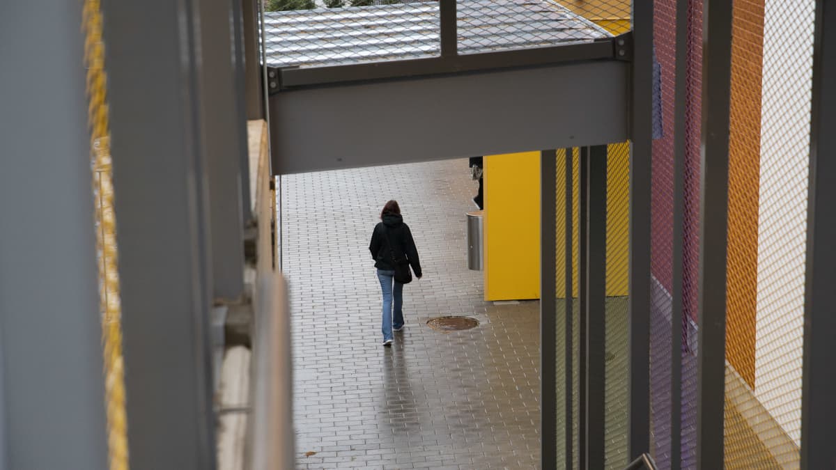 Nainen kävelee kohit Siilinjärven terveyskeskuksen ulko-ovea.