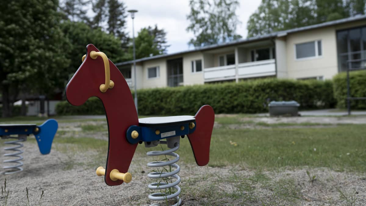 Lasten keinu ja taustalla asuinrakennus, jossa poliisi epäilee vanhempien murhanneen neljä-vuotiaan lapsen.