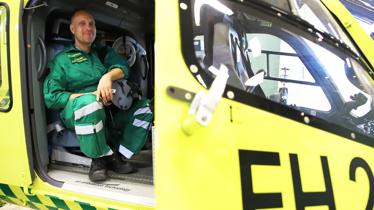 Mies istuu lääkärihelikopterissa.