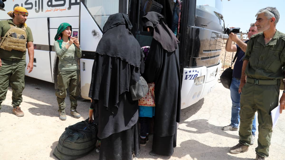Kvinnor stiger ombord på en buss i al-Hol-lägret i Syrien.