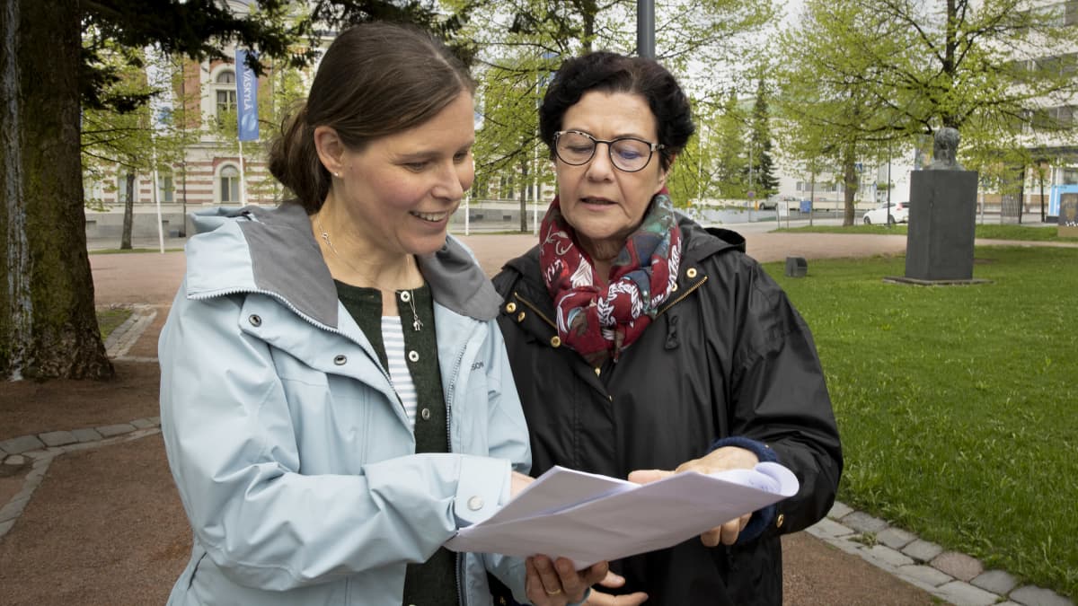 Kirsi Knuuttila ja Aila Paloniemi tutkivat muistiinpanojaan.