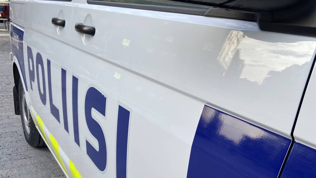 Poliisiauton kylki, jossa on sinisin kirjaimin teksti poliisi.