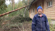 Jouni Varis talon edustalla, jonka päälle on kaatunut puu. 