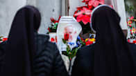 Toppatakkiset nunnat katselevat alttaria, jolle on tuotu paavi Franciskuksen kuvia ja kukkia.