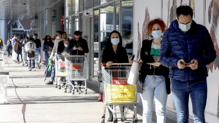 Asiakkaat odottivat hengityssuojaimet kasvoillaan ja turvavälit käytössä supermarketiin ennen pääsiäistä Milanossa.