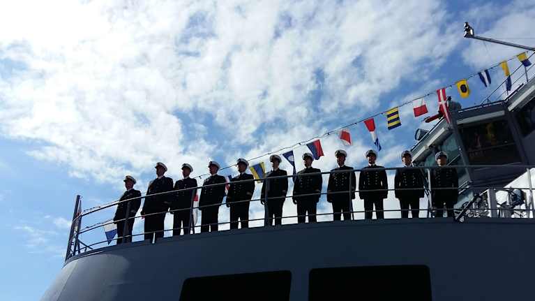 Marinofficerare står på kommandobryggan till ett av marinens örlogsfartyg.