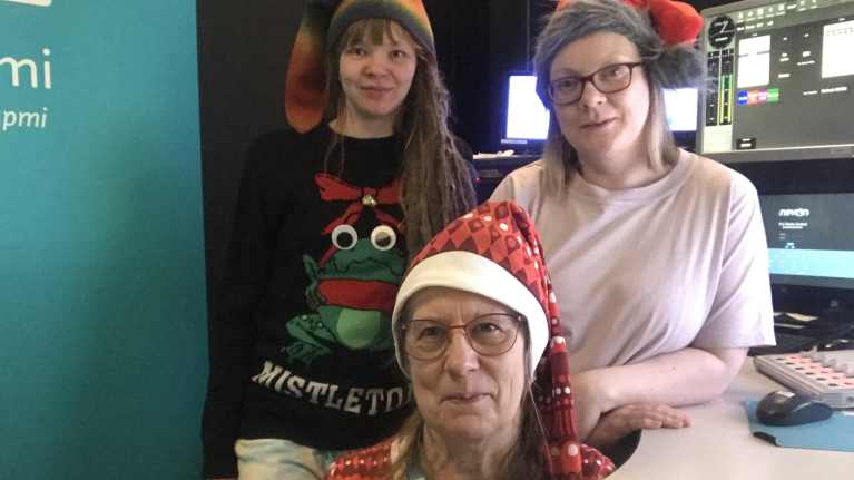 Toimittajat Janica Gauriloff, Susanna Guttorm ja Anja Kaarret tonttulakit päässä Yle Saamen studiossa.