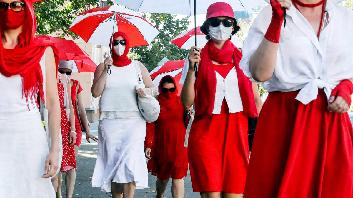 Valkovenäläisiä naisia osoittamassa mieltä kadulla punavalkoisiin pukeutuneena.