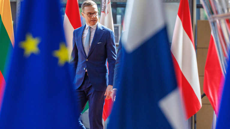 Alexander Stubb kävelee EU-maiden lippujen välissä Brysselissä.