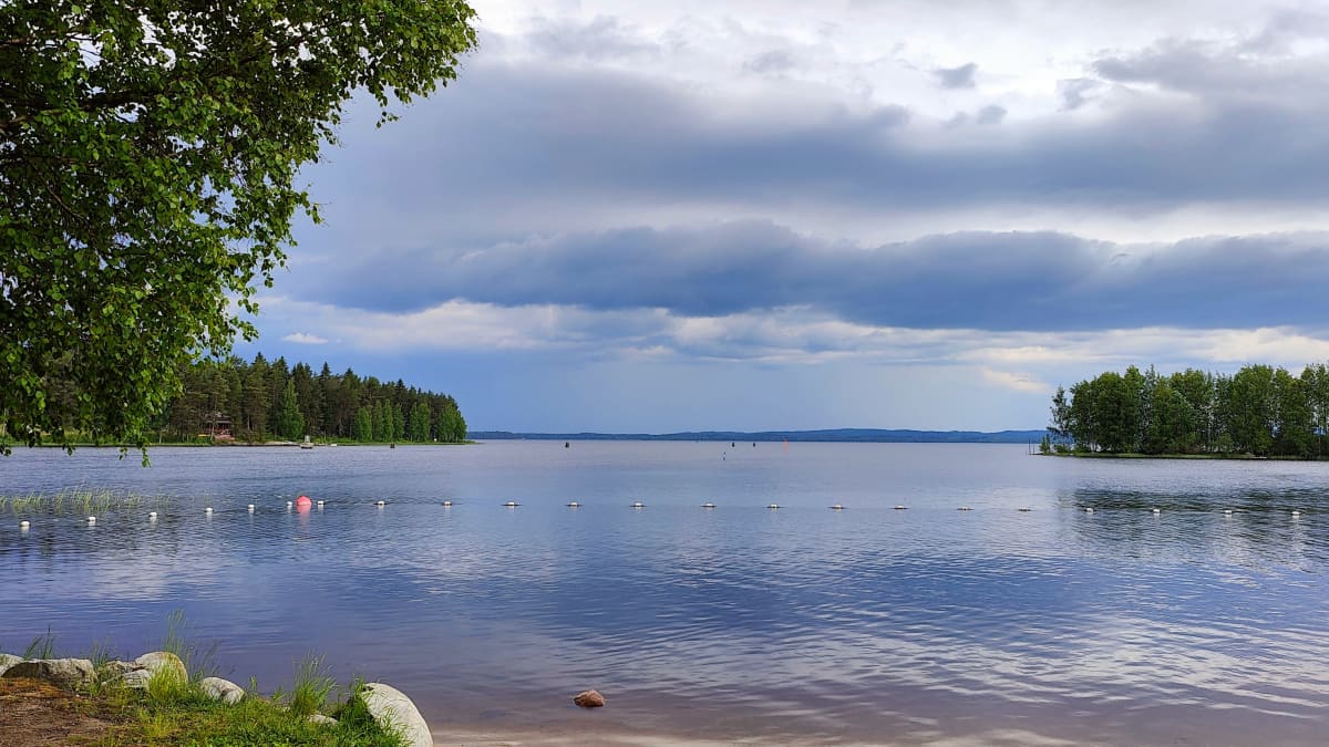 Kuvassa näkyy järvimaisema ja ukkospilvi.