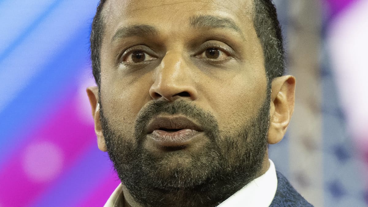 Kash Patel, tummapartainen mies sinisessä pikkutakissa. 