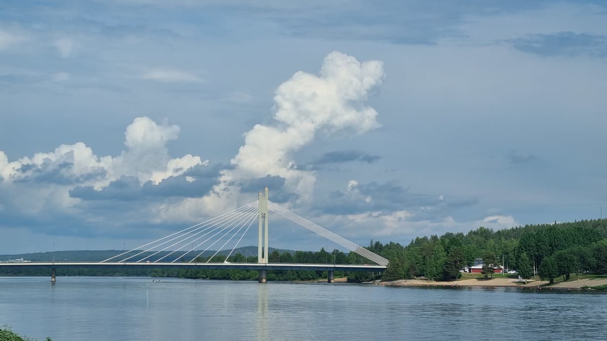 Ukkospilviä nousemassa Rovaniemellä. Ounasjoki ja siltä yli joen. 