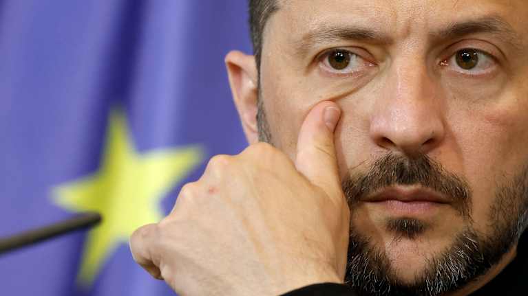 Volodymyr Zelenskyi kasvot lähikuvassa. Hän pyyhkäisee silmän alustaan peukalollaan.