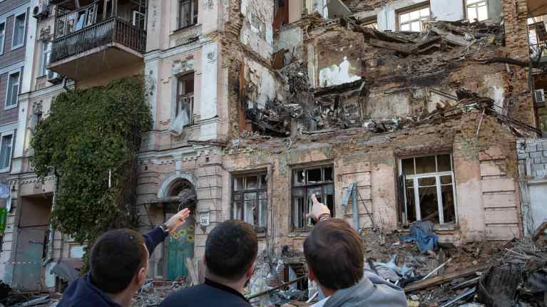 Ukrainalaiset osoittavat asuinrakennusta joka tuhottu oletettavasti  Shahed-136-lennokilla.