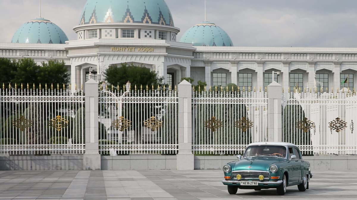 Sininen Volga-auto on suuren sinikupolisen palatsin edustalla.