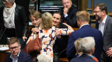 Sanna Marin halaa Anna-Maja Henrikssonia. Muut kansanedustajat ovat kerääntyneet ympärille.