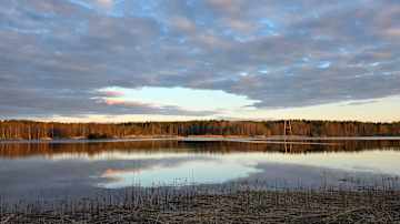 Tyyni järvimaisema. Pilvipeite repeilee.