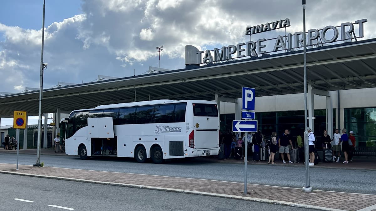 Tampere-Pirkkala lentokenttä ulkoa kuvattuna, ihmiset odottavat bussiin 25.7., matkalla Rodokselle.