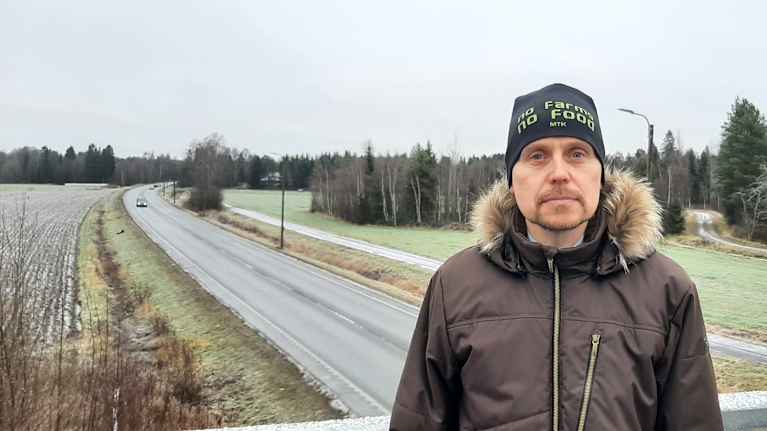 Man står på bro ovanför väg.
