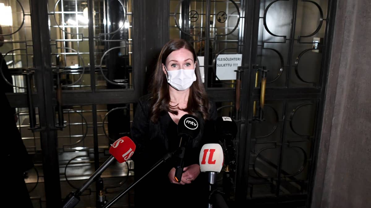 Statsminister Sanna Marin (SDP) svarar på journalisters frågor utanför riksdagen den 21 december 2020.