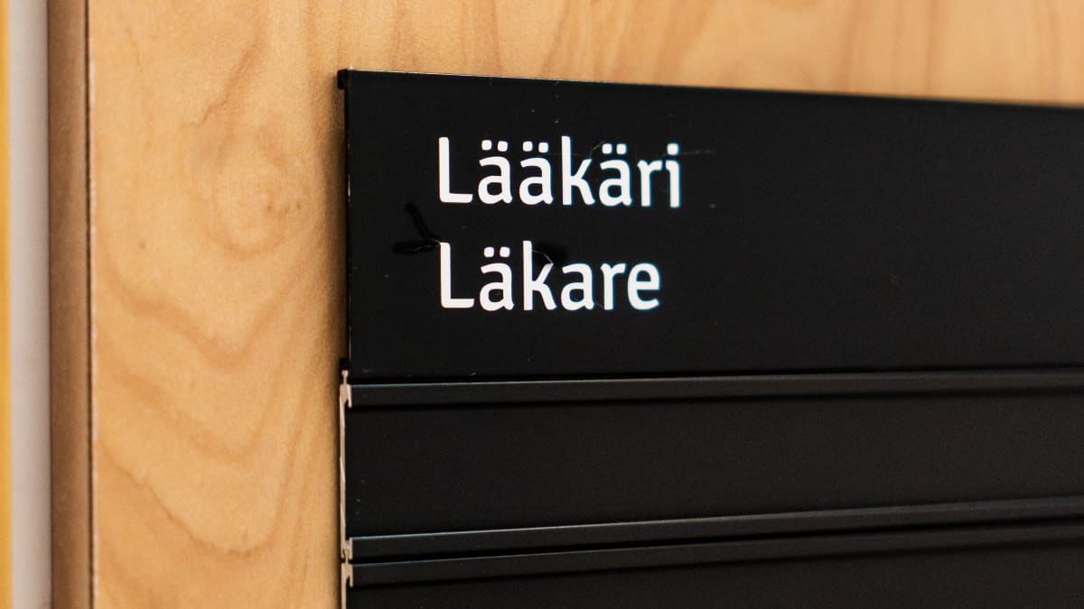 Lääkärikyltti ovessa suomeksi ja ruotsiksi.