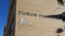 En skylt med texten Turun Poliisilaitos på Åbo polisstations gula tegelvägg.