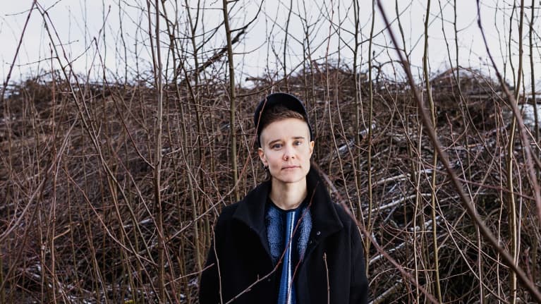 Emilia Kokko seisoo risukasan edessä joutomaalla