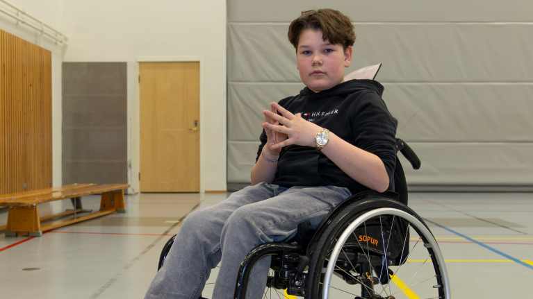Keminmaalainen Elias Löf kokeilemassa pyörätuolia koulun liikuntasalissa.