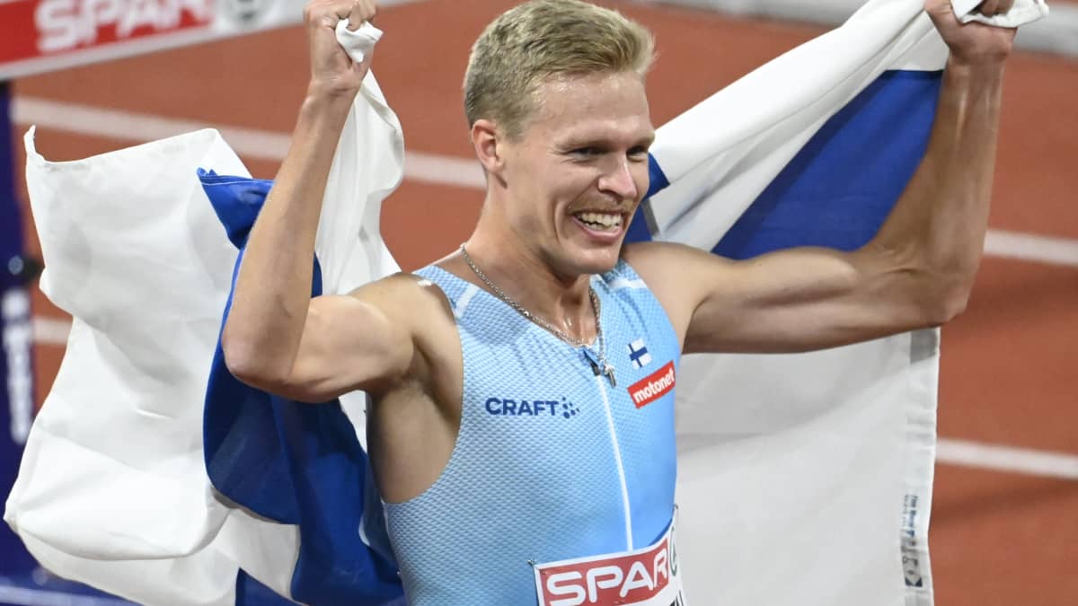 Topi Raitanen tuulettaa Suomen lipun kanssa.
